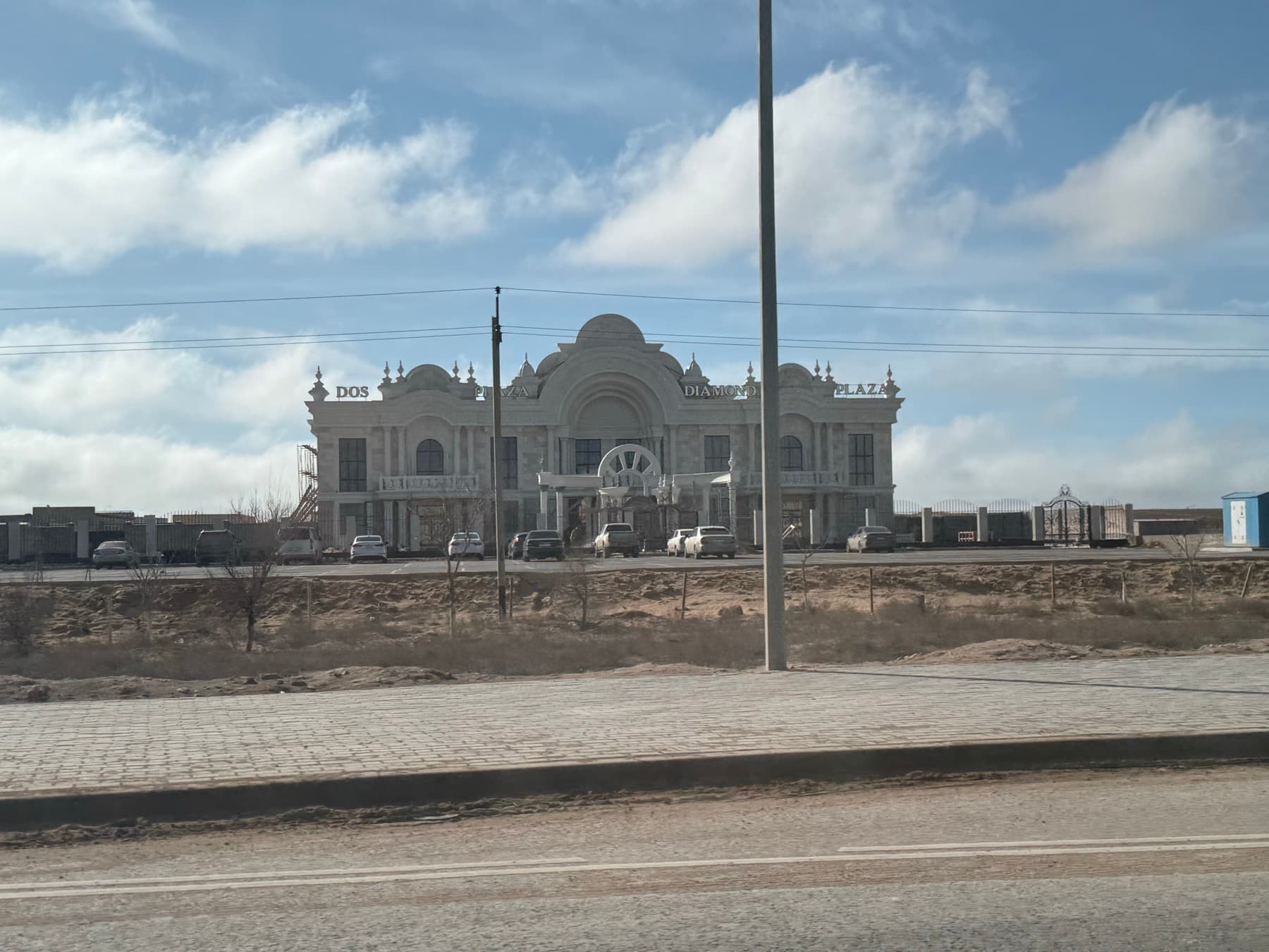 Здание у дороги в Актау под облачным небом