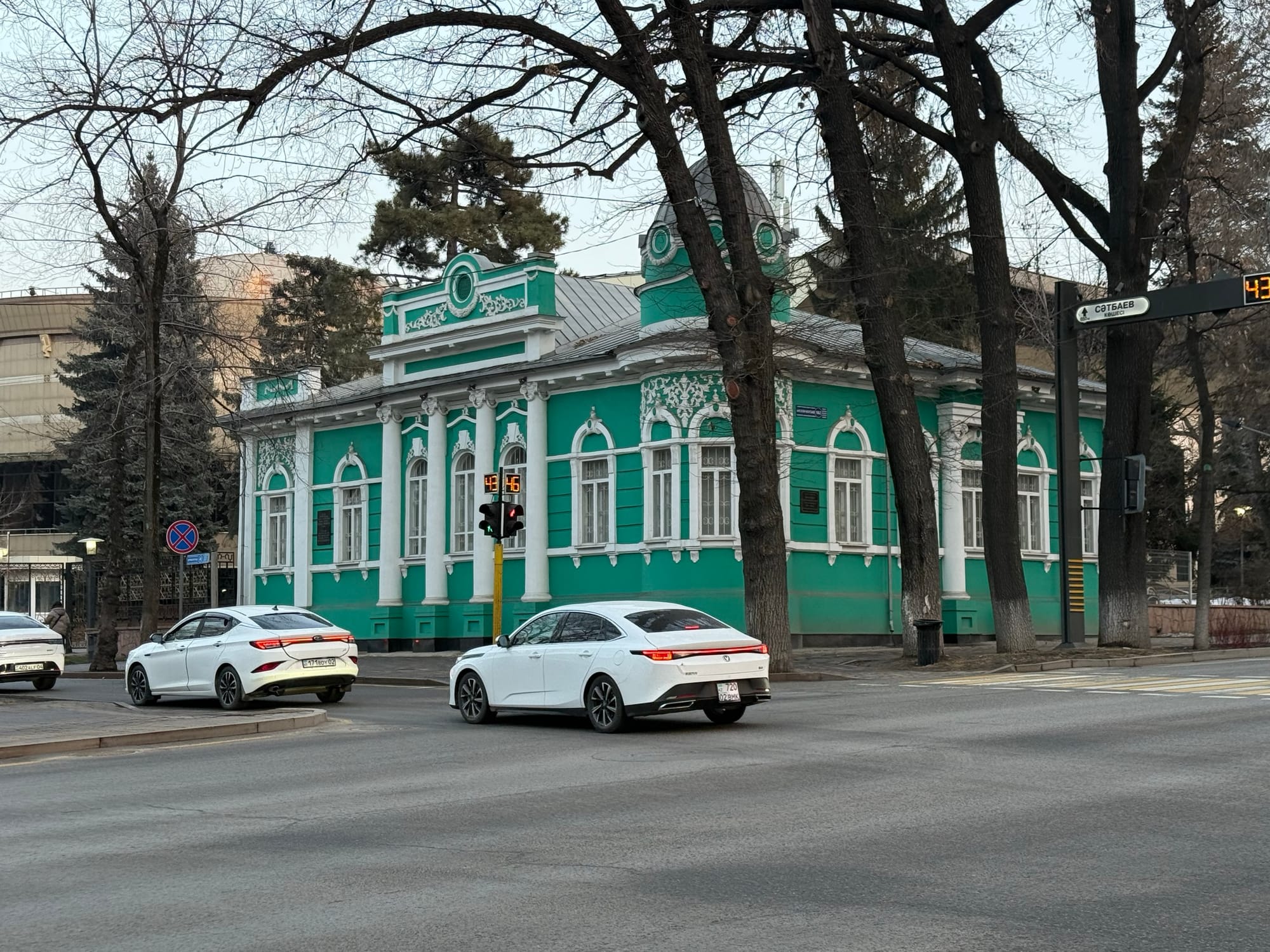 Зелёное историческое здание на зимней улице Алматы
