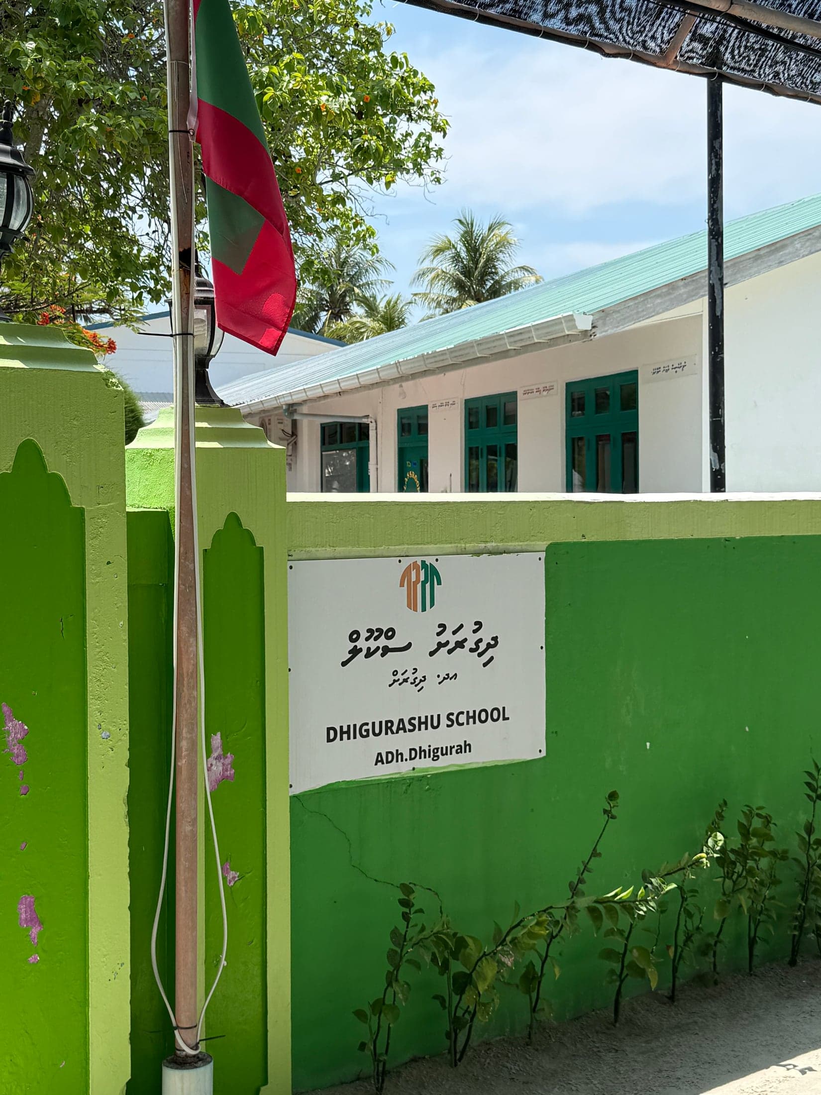 Табличка Dhigurah Council на зелёной стене