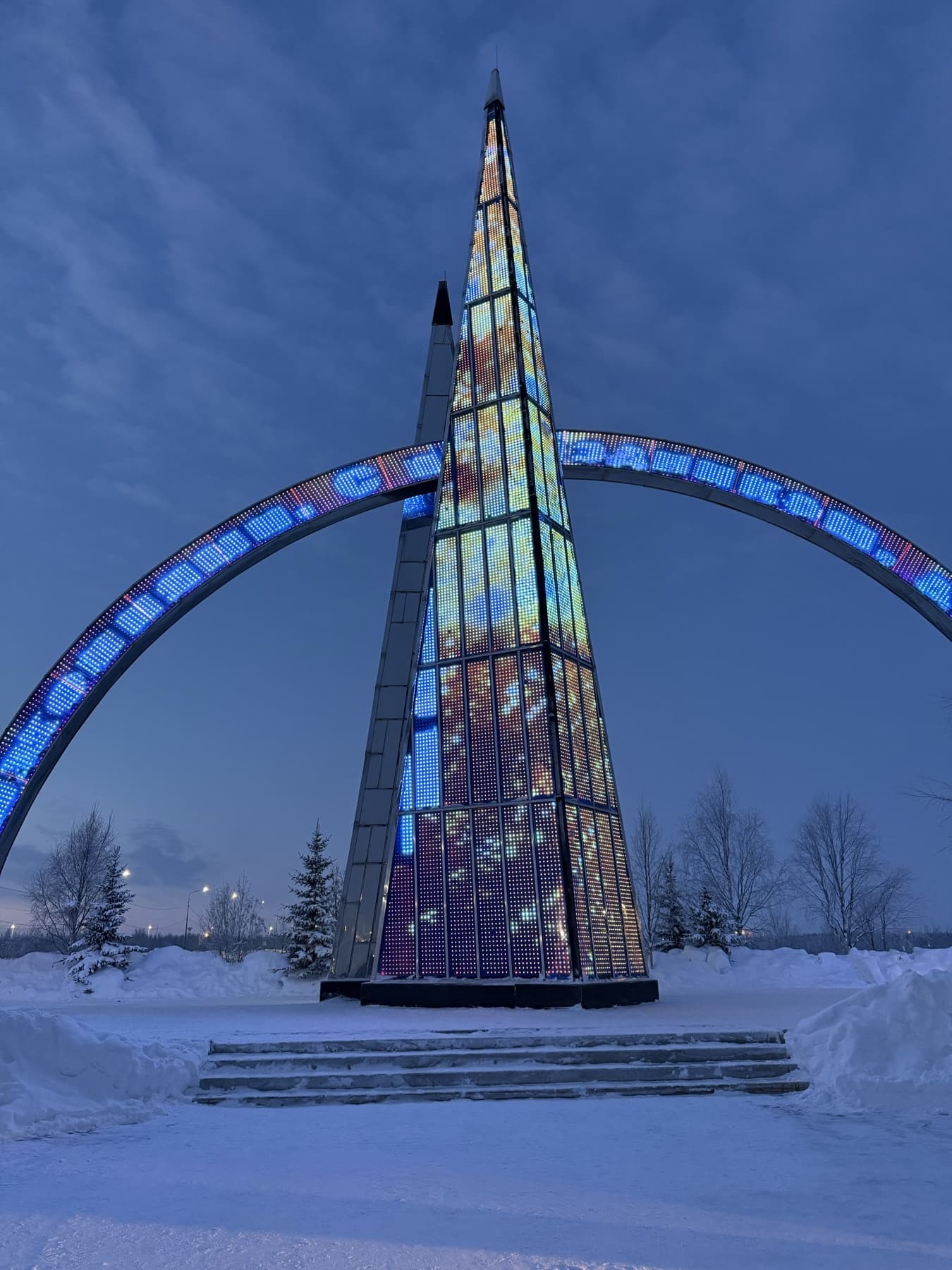 Подсвеченная стела в Салехарде вечером